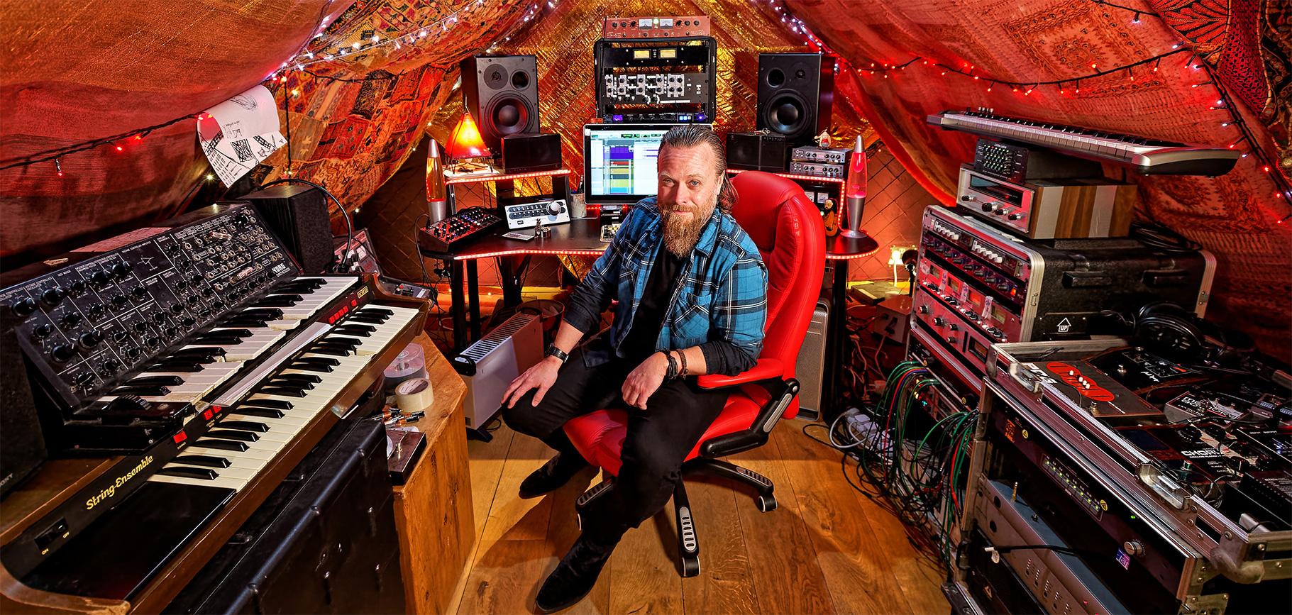 Dave Eringa sat in cozy studio with fairy lights and blankest on the walls