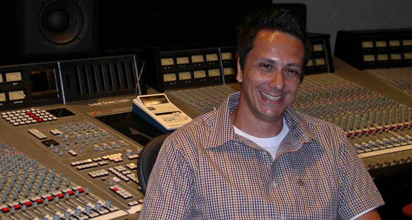 Jason Goldstein sat in front of large analogue mixing desk