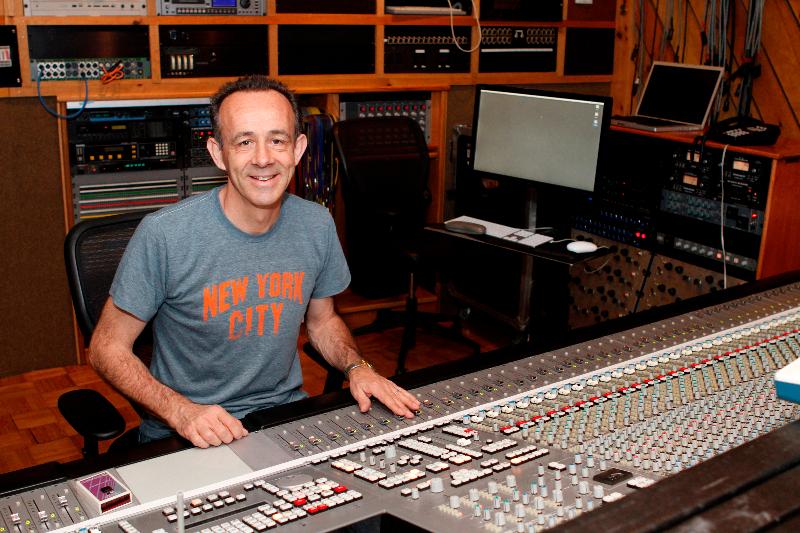 Kevin Killen sat at mixing desk in studio