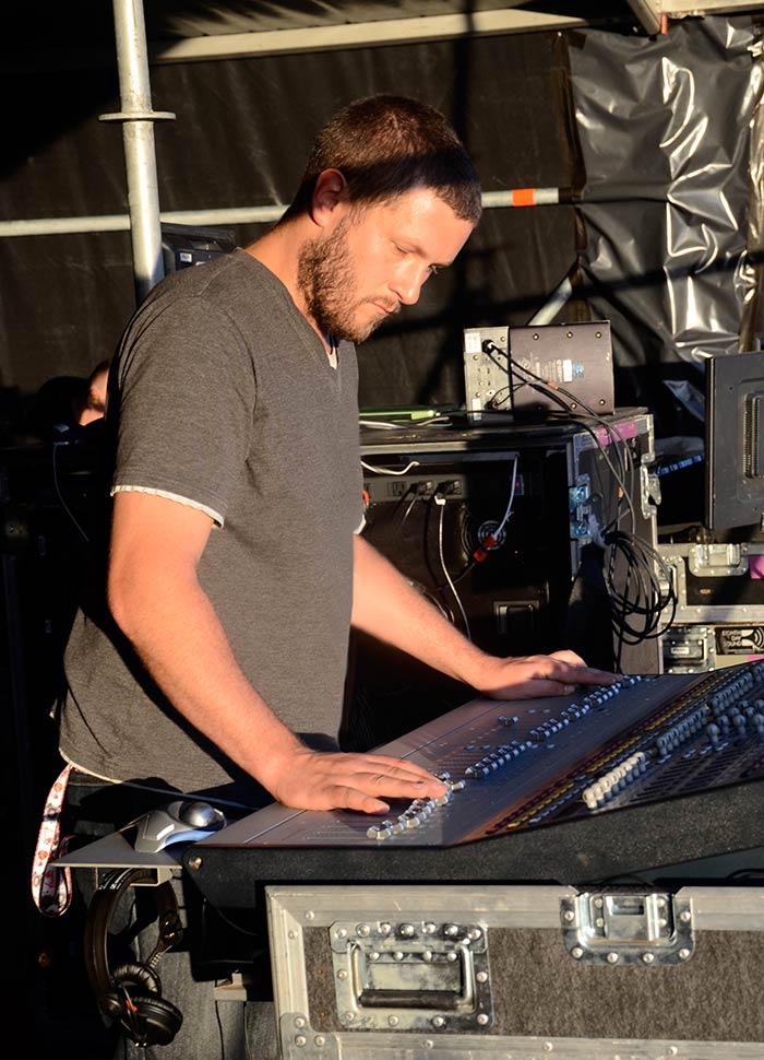 Richard Nicholson operating a live sound desk at a festival outdoors