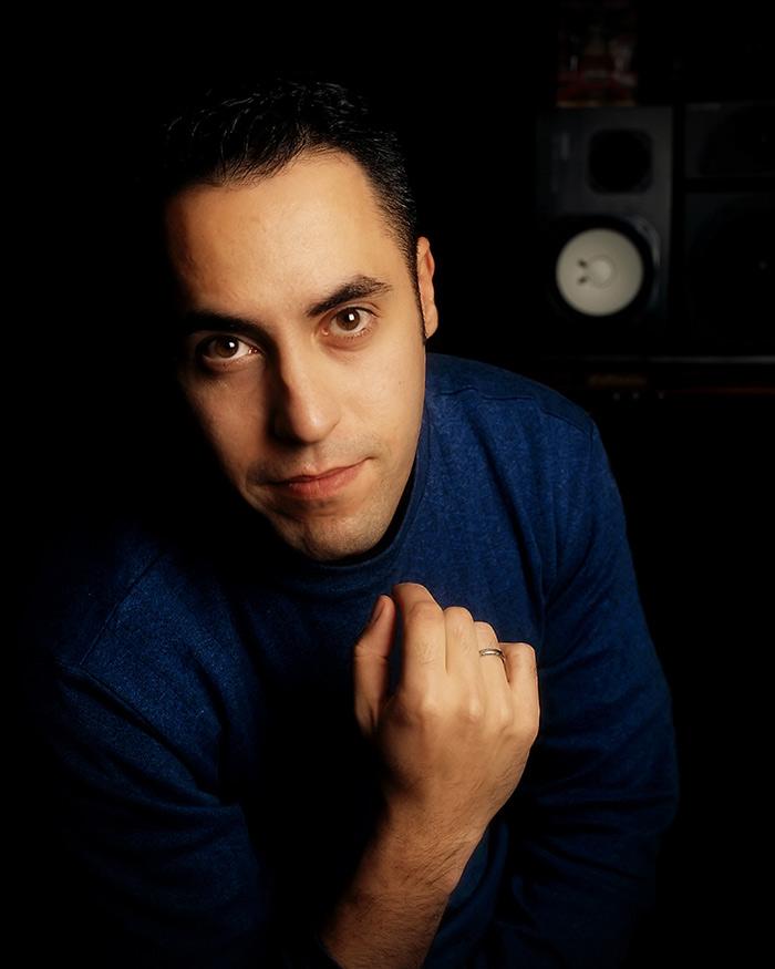 Closeup of Tom Salta in a mixing studio with a speaker in the background